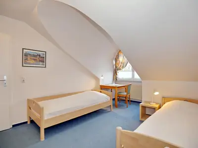 Schlafzimmer mit Tisch und Stuhl