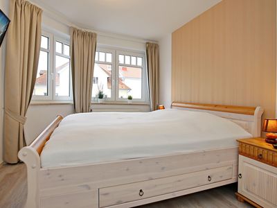 Schlafzimmer mit Doppelbett und TV