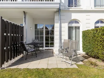 Terrasse mit Gartenmöbeln und Grünfläche