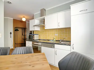 Küche mit Esstisch und Zugang zum Balkon