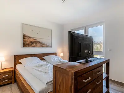 erstes Schlafzimmer mit Doppelbett und TV