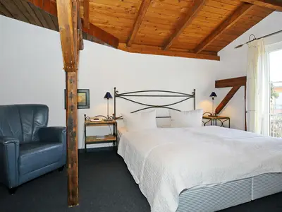 Schlafzimmer mit Doppelbett und Sessel