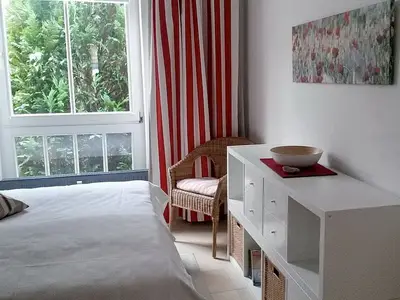 Schlafzimmer mit Doppelbett und Korbsessel