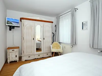 Schlafzimmer mit Kleiderschrank und TV