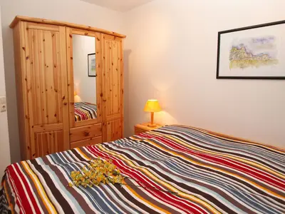 Schlafzimmer mit Doppelbett und Kleiderschrank