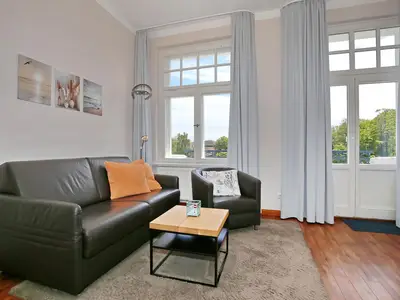 Wohnzimmer mit Schlafcouch und Sessel