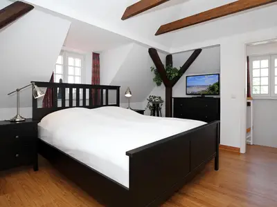 Schlafzimmer mit Doppelbett und TV