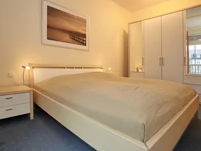 erstes Schlafzimmer mit Doppelbett und Kleiderschrank