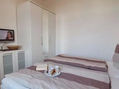 erstes Schlafzimmer mit Kleiderschrank und TV