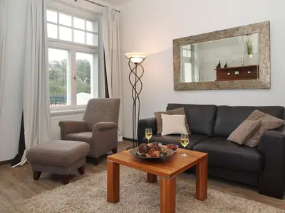 Wohnzimmer mit Couch und Sessel