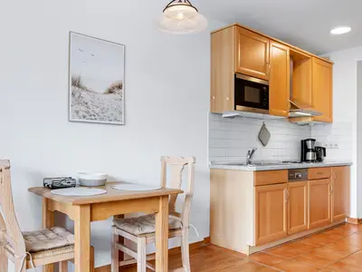 Wohn-Essbereich mit Esstisch und Küchenzeile