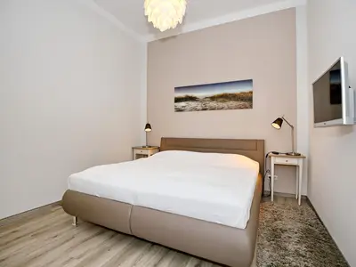 Schlafzimmer mit Doppelbett und TV