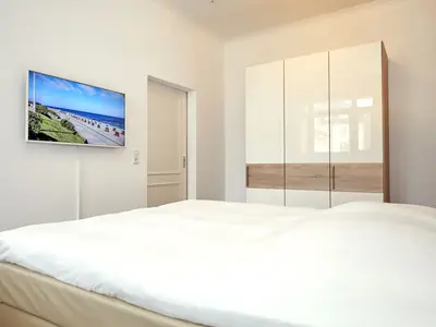 erstes Schlafzimmer mit Boxspringbett und Kleiderschrank