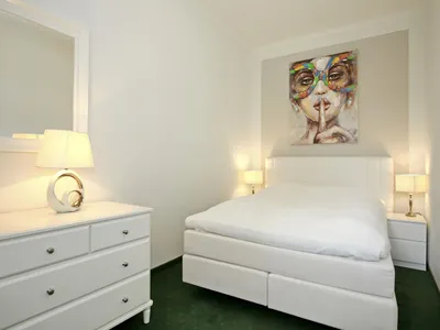 zweites Schlafzimmer mit Boxspringbett und Kommode