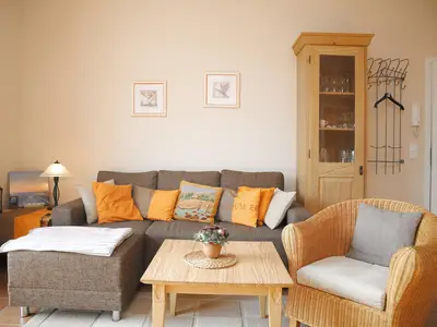 Wohnzimmer mit Ecksofa und Korbsessel