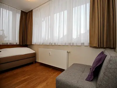 zweites Schlafzimmer mit Boxspringbett und Klappbett