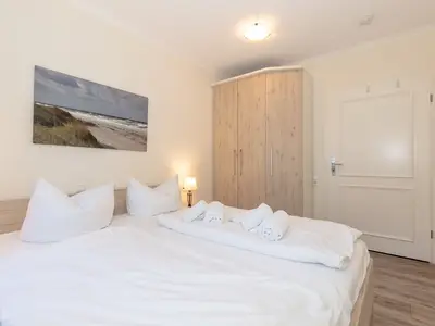 Schlafzimmer mit Doppelbett und Kleiderschrank