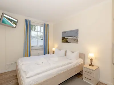 Schlafzimmer mit Doppelbett und Flatscreen TV