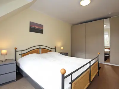 erstes Schlafzimmer mit Doppelbett und Kleiderschrank