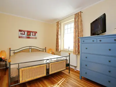 Schlafzimmer mit Doppelbett und TV