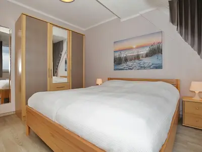 Schlafzimmer mit Doppelbett und Kleiderschrank