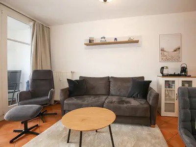 Wohnzimmer mit Schlafsofa und Sessel