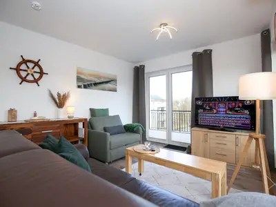 Wohnzimmer mit Sofa, Sessel und TV