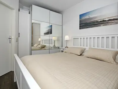 Schlafzimmer mit Doppelbett und Kleiderschrank