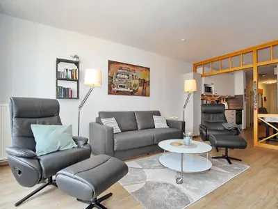 Wohnzimmer mit Schlafcouch und Sesseln