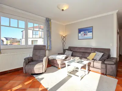 Wohnzimmer mit Ecksofa und Sessel