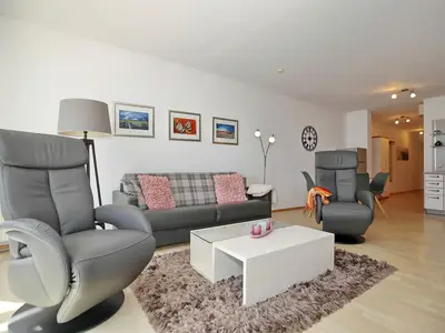 Wohnzimmer mit Schlafcouch und Sesseln