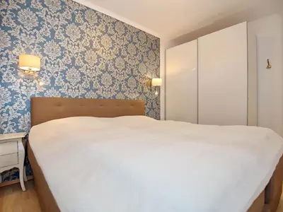 Schlafzimmer mit Doppelbett und Kleiderschrank