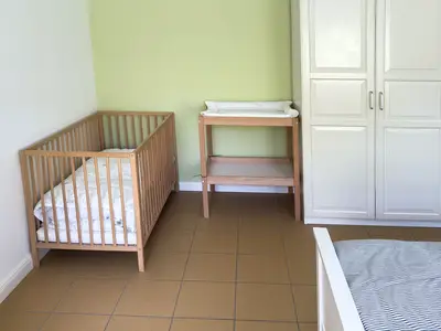 Schlafzimmer mit Doppelbett und einem Kinderbett