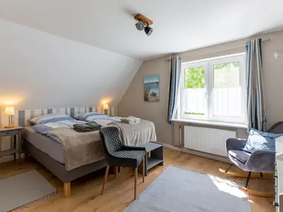 Schlafzimmer mit Boxspringbett und extra Sitzmöglichkeiten