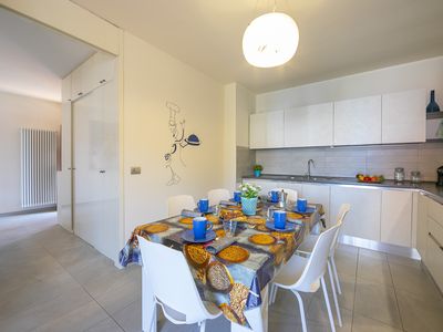 Vollständig ausgestattete Küche mit Esstisch und Zugang zum Balkon