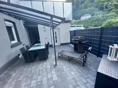 Terrasse mit Gasgrill und überdachtem Außenessbereich