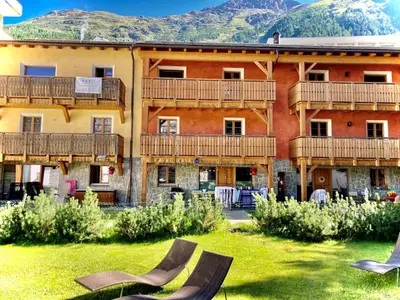 Aussenansicht (roter Hausteil links). Balkone oben und unten gehören zur Wohnung