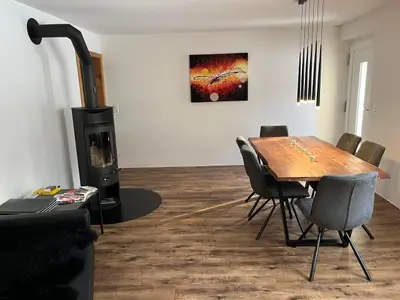 Wohnzimmer mit Esstisch und Holzofen