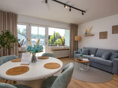 Wohnzimmer mit großem Schlafsofa und Esstisch für bis zu 4 personen