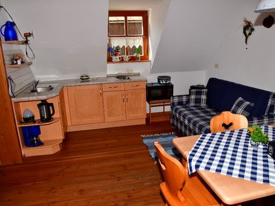 Voll ausgestattete Wohnküche mit Essecke und Sofa