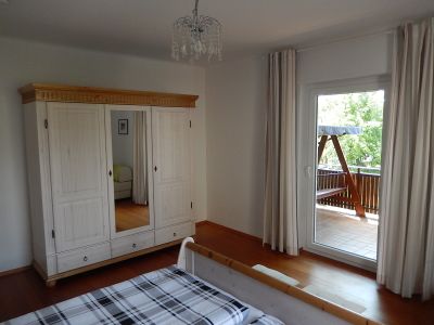 Schlafzimmer mit Kleiderschrank und Balkon