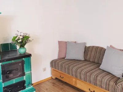 Wohnzimmer mit Couch und Kachelofen Fewo Rosi