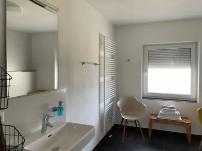 Ferienwohnung 16 - Badezimmer mit ebenerdiger Dusche und Fenster