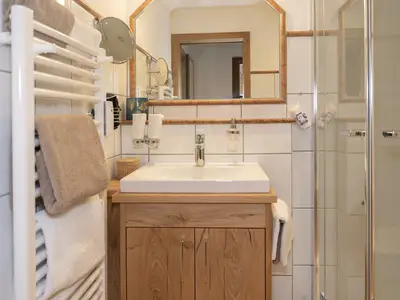 Das komfortable Bad verfügt über eine ebenerdige Dusche und Shower Pipe.