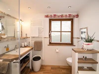 Luxuriös modern und doch einladend gemütlich: das Bad der Kaiserwinkl Exklusiv mit Badewanne und ebenerdiger Regendusche.