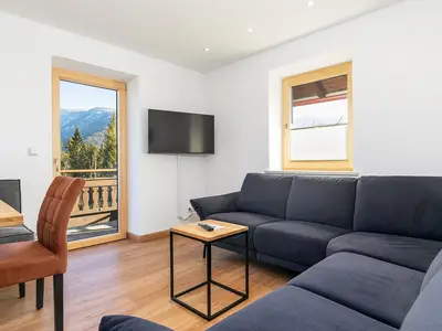 Couchbereich mit Balkonzugang und Bergblick