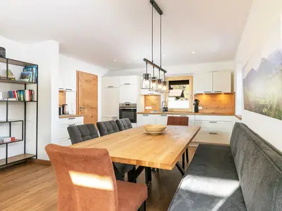 Esstisch und moderne Küche im Hintergrund