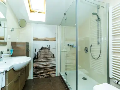 Renoviertes, zeitgemäßes Bad mit Dusche und Handtuchheizkörper