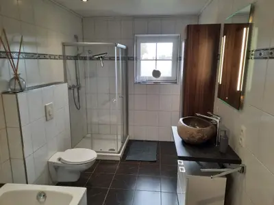 Das große Badezimmer mit Badewanne und Dusche