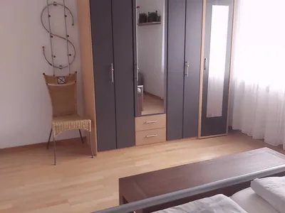 Schalfzimmer mit großem Kleiderschrank und Fernseher